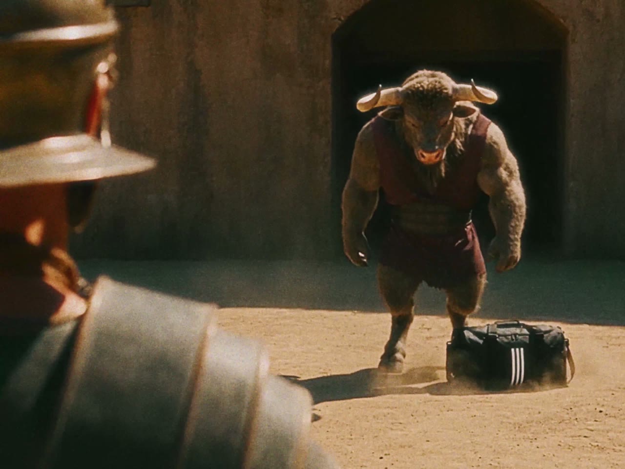 A minotaur walks into the arena with a branded gym bag